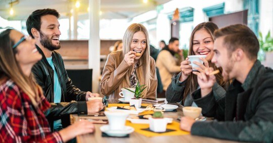 Friends Laughing under Cafe umbrella
