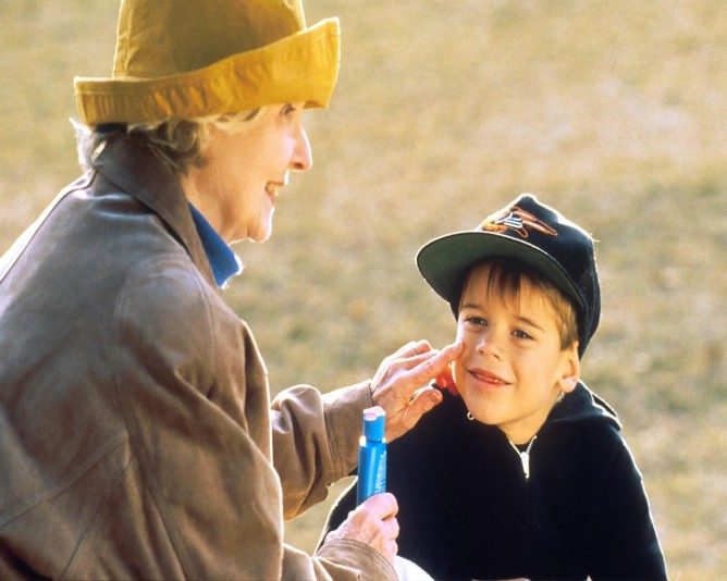 Granmom applying sunscream to grandson