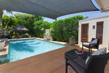 Two black chairs next to open pool