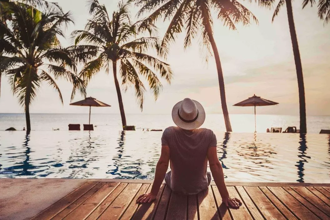 Man sitting by resort pool